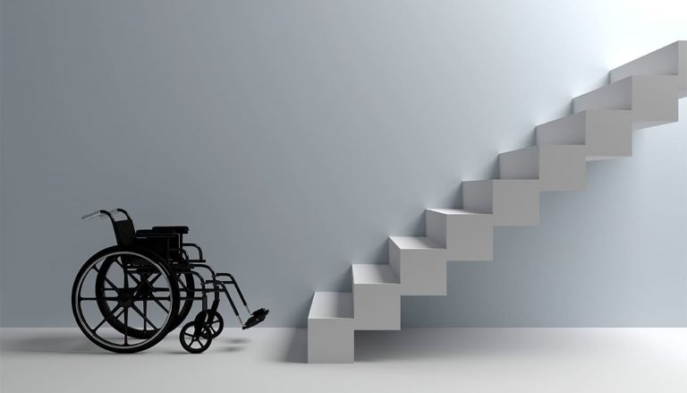 Cadeira de roda na frente de uma escada